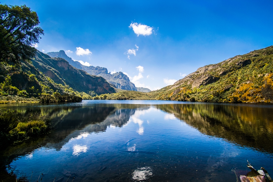 Clouds reflect in a pool of calm water at day, Photographed during trekking adventure at Mount Rwenzori in Rwenzori National Park, Uganda and DR Congo Photography Uganda Tourism Board