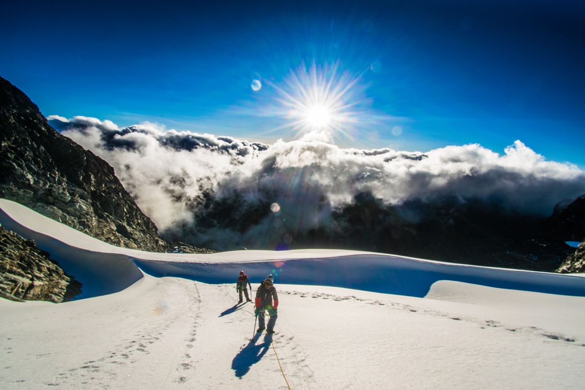 A photograph of tourists on the Rwenzori mountains captured during a hiking experience in Rwenzori Mountains National Park in Western Uganda.