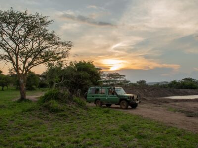 A photograph of a touring vehicle captured during a game drive in Lake Mburo National Park in Nyabushozi County, Kiruhura District in Uganda.