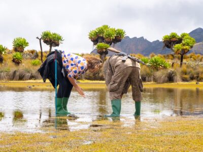 A photogragh of a Ranger guide and tourist at Jacksons Pool during the Uganda hiking and walking tour in Mount Elgon National Park located both in Uganda and Kenya.