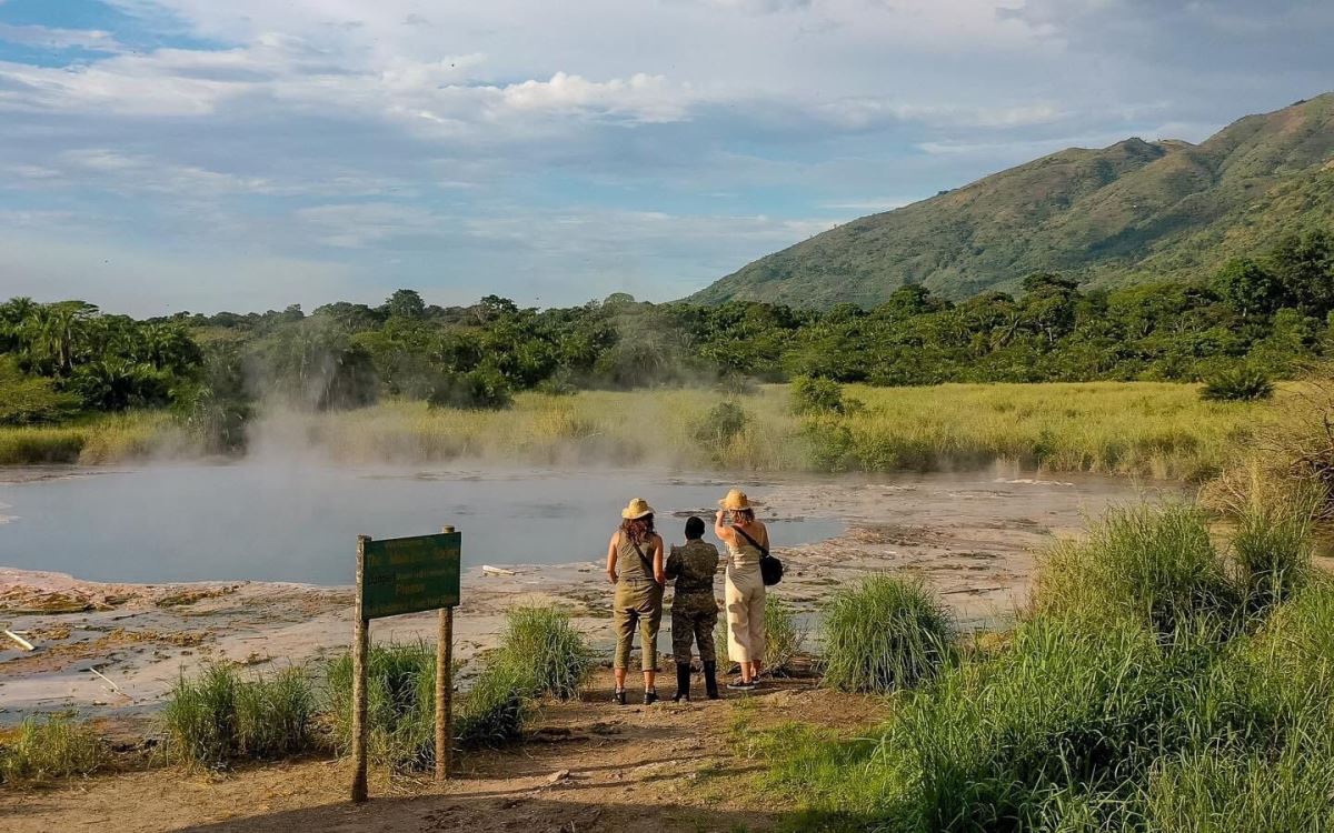 A photograph of a ranger guide and tourists at Sempaya Hotsprings taken in Semuliki National Park in Western Uganda.