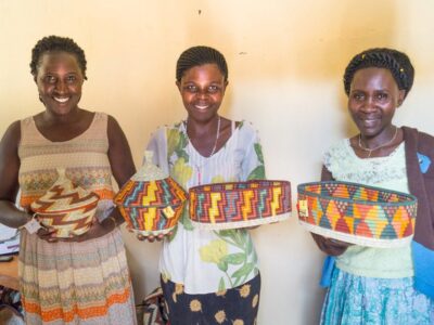 A photograph of women holding baskets taken during a village tour in Rubona located along Fort Portal–Kasese–Mpondwe Road in Uganda