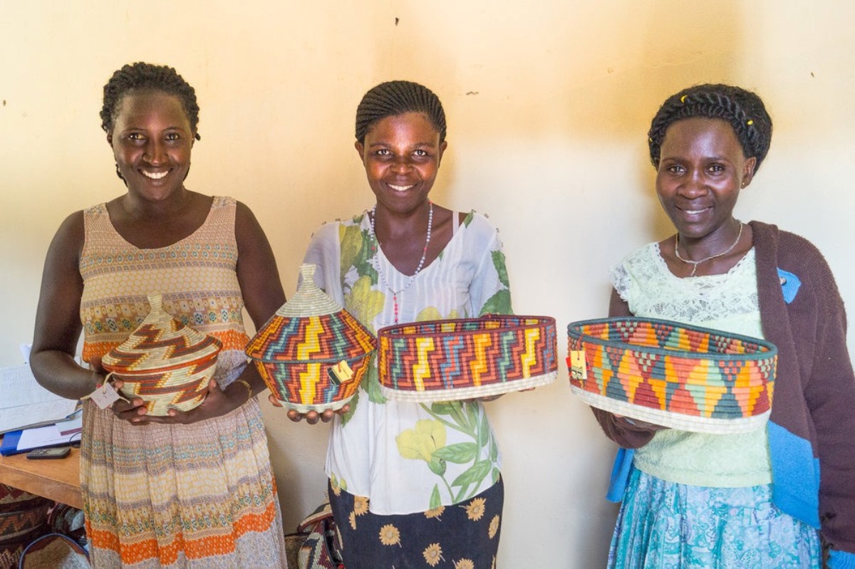 A photograph of women holding baskets taken during a village tour in Rubona located along Fort Portal–Kasese–Mpondwe Road in Uganda