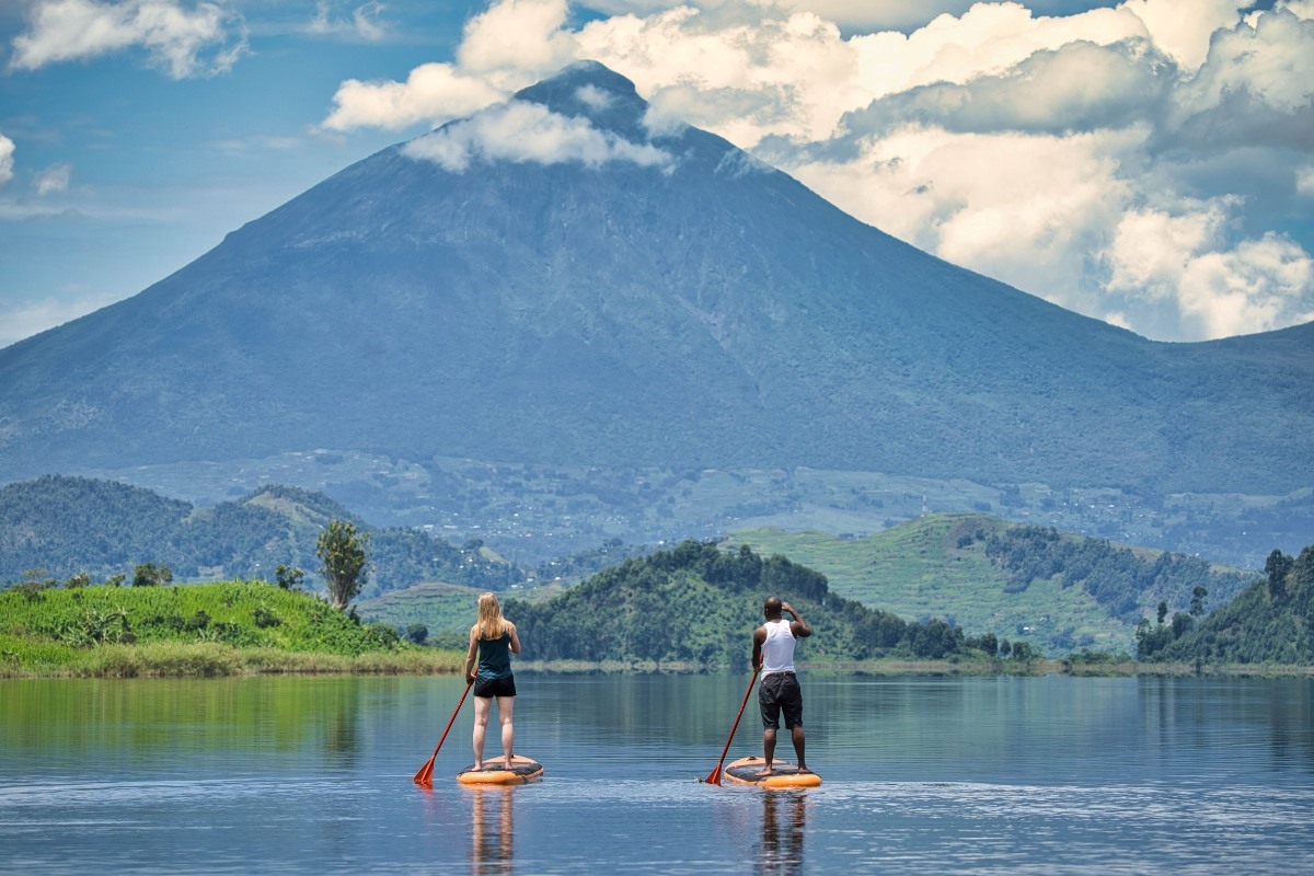 A photograph of a tourist and her guide take during a Stand Up Paddle tour on Lake Mutanda in Western Uganda