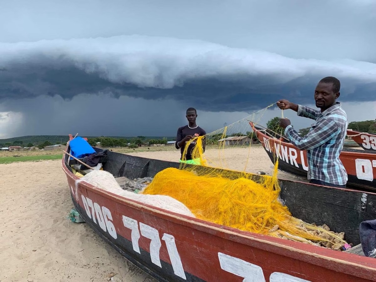 A photograph of fishermen detangling their fishing net taken during a tour to Lake Edward in the Albertine Rift of Uganda.