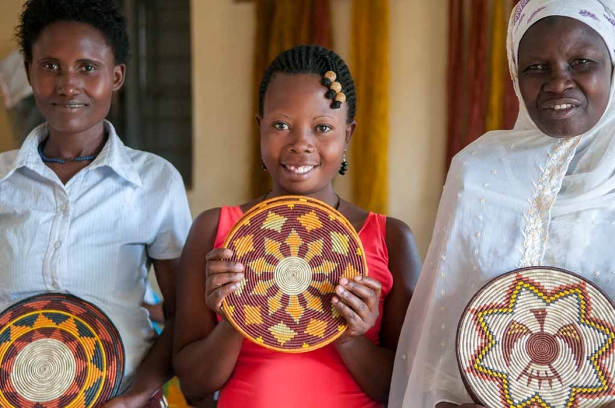 A photograph of women holding baskets taken during a village tour in Rubona located along Fort Portal–Kasese–Mpondwe Road in Uganda