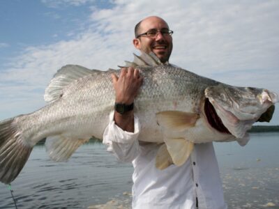 A photograph of a tourist holding a Nile Perch fish taken during a fishing trip in Uganda