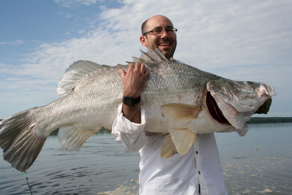 A photograph of a tourist holding a Nile Perch fish taken during a fishing trip in Uganda