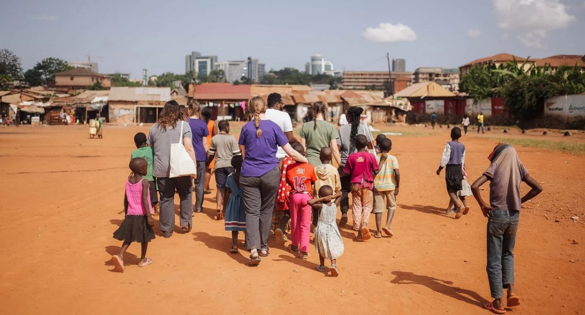 A photograph of tourists and the local kids taken during a village tour in Jinja in Eastern Uganda.