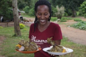 Photograph of a visitor holding the plates with traditional food taken during an Entanda cultural Experience