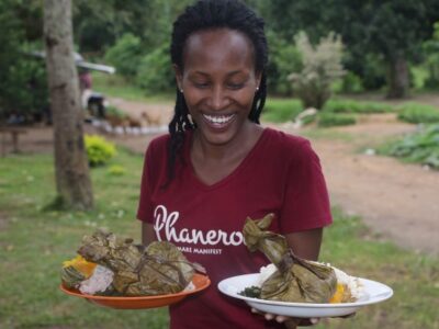 Photograph of a visitor holding the plates with traditional food taken during an Entanda cultural Experience