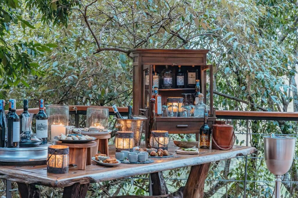 Photograph of food and wine set up on an outdoor balcony at Mara Toto Tree Camp