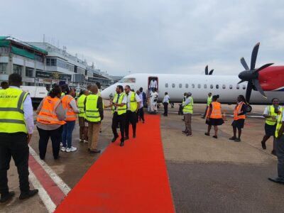 Passengers disembark from the Kush Airlines aircraft at Entebbe International Airport in Entebbe.