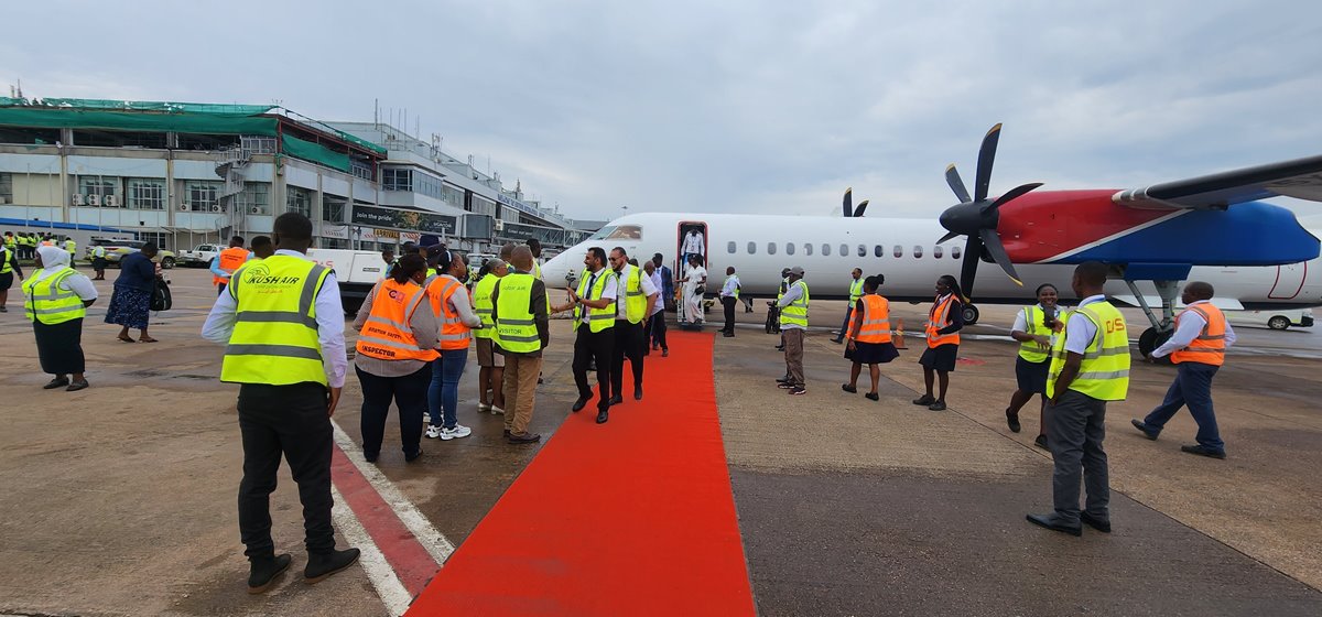 Passengers disembark from the Kush Airlines aircraft at Entebbe International Airport in Entebbe.