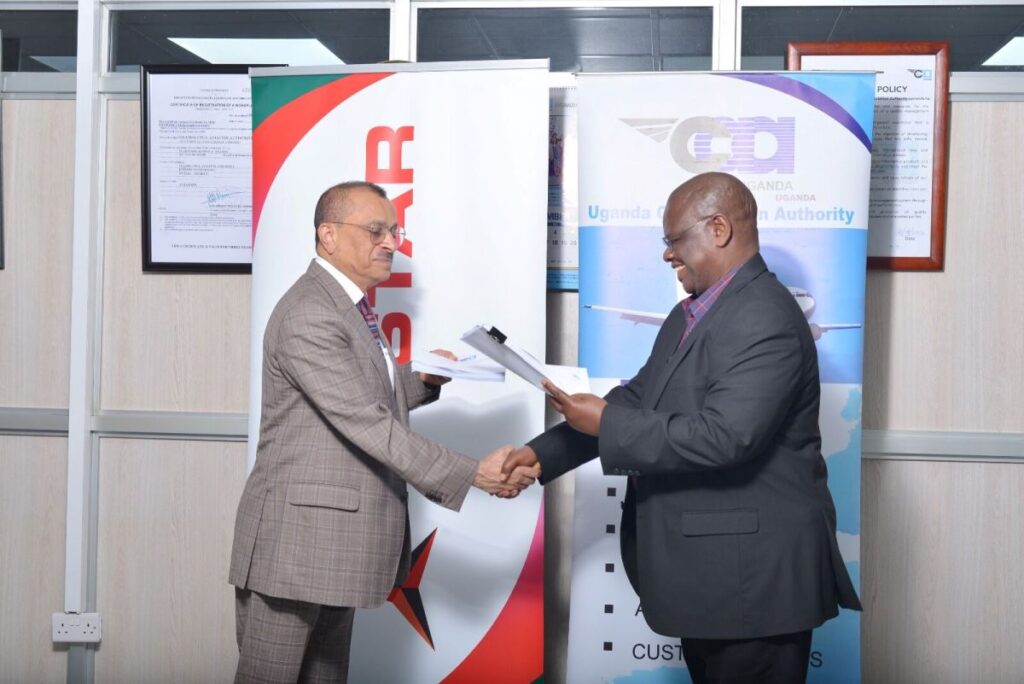 Photograph of the Director General of UCAA, Mr. Fred Bamwesigye shaking hands with the Group Chief Executive of Tristar, Mr. Eugene Mayne