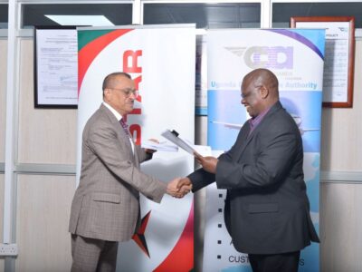 Photograph of the Director General of UCAA, Mr. Fred Bamwesigye shaking hands with the Group Chief Executive of Tristar, Mr. Eugene Mayne