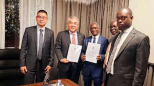 Chairman Tian Tang group, Mr. Paul Zhang Zhigang, and Prof. James Kalema showing copies of the signed concession agreement. On the far right is the Hon. Bahinduka Mugarra Martin the Minister of State for Tourism,Wildlife and Antiquities.