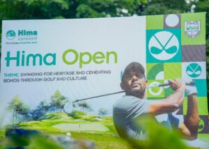 Photograph showing the vibrant promotional banner for the Hima Open golf tournament set against the lush green backdrop of Toro Golf Club in Fort Portal, Uganda