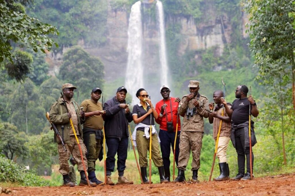 Photograph of CEO of Uganda Tourism Board Julie Kagwa and team posing with their ranger guides at the Sipi Falls in Eastern Uganda