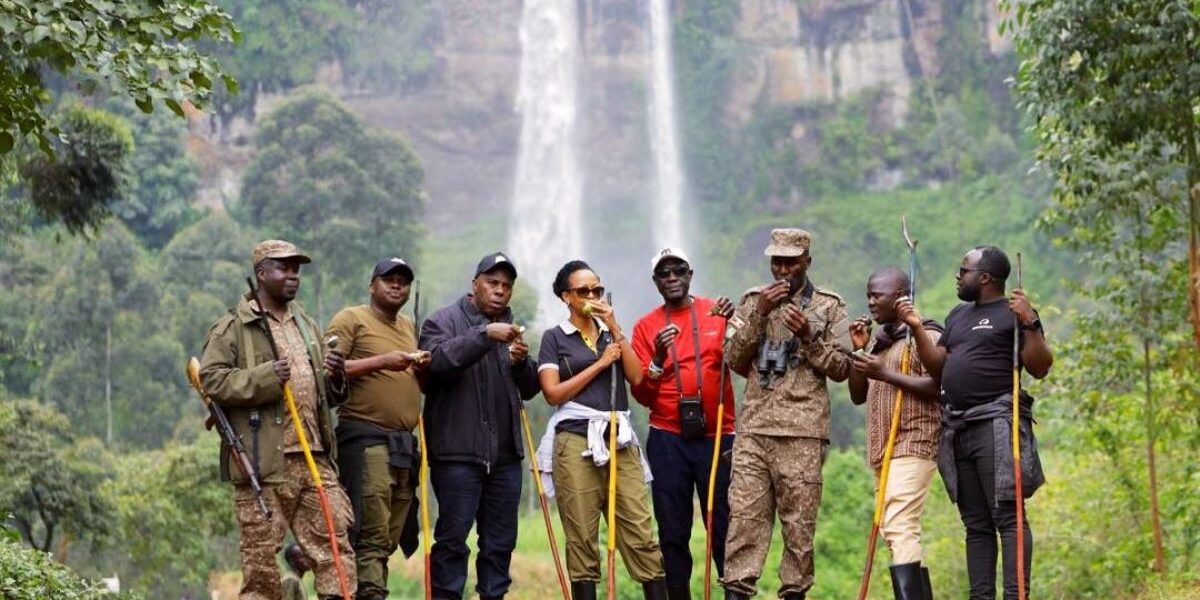 Photograph of CEO of Uganda Tourism Board Julie Kagwa and team posing with their ranger guides at the Sipi Falls in Eastern Uganda