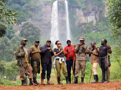 Photograph of CEO of Uganda Tourism Board Julie Kagwa and team posing with their ranger guides at the Sipi Falls in Eastern Uganda