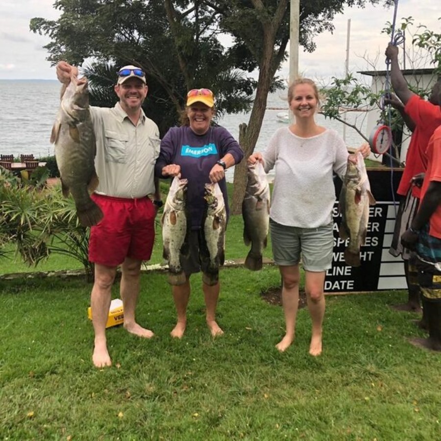 Photograph of visitors with their fish taken during fishing competitions at Entebbe Sailing Club in Entebbe, Uganda