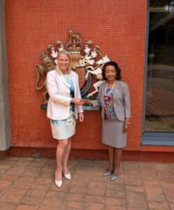 Photograph of the President of the Uganda Tourism Association (UTA), Mrs. Yogi Biriggwa, shaking hands with the British High Commissioner to Uganda, H.E. Lisa Chesney MBE