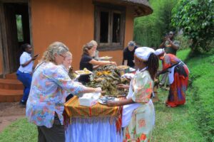 Photograph of the German Travel Agents getting served with the Ugandan Local food at Ewaffe Cultural Village in Mukono, Uganda
