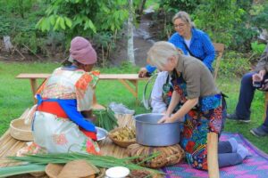 Photograph of German travel agents preparing a local meal during a cultural tour at the Ewaffe Cultural Village in Mukono, Uganda