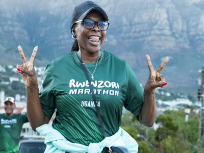 A happy participant promotes the Rwenzori Marathon, Uganda, against the stunning backdrop of Table Mountain