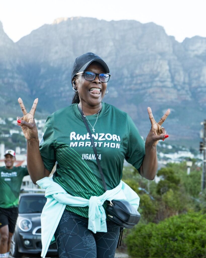 A happy participant promotes the Rwenzori Marathon, Uganda, against the stunning backdrop of Table Mountain