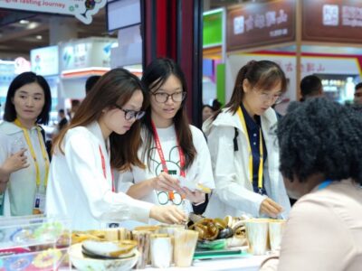 Chinese visitors enjoying a product tasting session at the Uganda booth, sampling high-quality Ugandan exports at the 2026 Canton Fair Uganda Canton Fair 2026