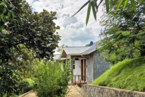 Family cottage at Mirima Kibale Lodge surrounded by lush greenery near Kibale National Park