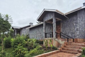 Entrance to a luxury cottage at Mirima Kibale Lodge featuring stone walls and wooden details