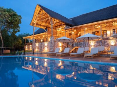 Stunning evening glow at Pabidi Lodge’s swimming pool, reflecting the elegant thatched-roof main lodge nestled in the forest Stunning evening glow at Pabidi Lodge’s swimming pool, reflecting the elegant thatched-roof main lodge nestled in the forest