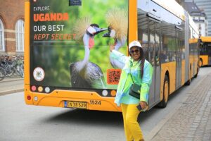 Uganda tourism representative proudly poses beside a campaign bus in Copenhagen