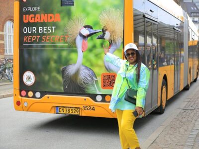 Uganda tourism representative proudly poses beside a campaign bus in Copenhagen Uganda tourism representative proudly poses beside a campaign bus in Copenhagen
