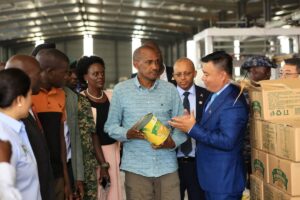 Agriculture Minister Frank Tumwebaze and Chinese partners inspect a can of pineapple at the Luwero processing factory during the launch of Uganda’s first canned pineapple shipment to China