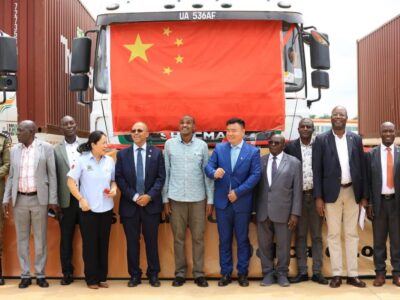 Ugandan officials, led by Agriculture Minister Frank Tumwebaze, pose with Chinese partners in front of the truck carrying the historic first shipment of Ugandan canned pineapples to China