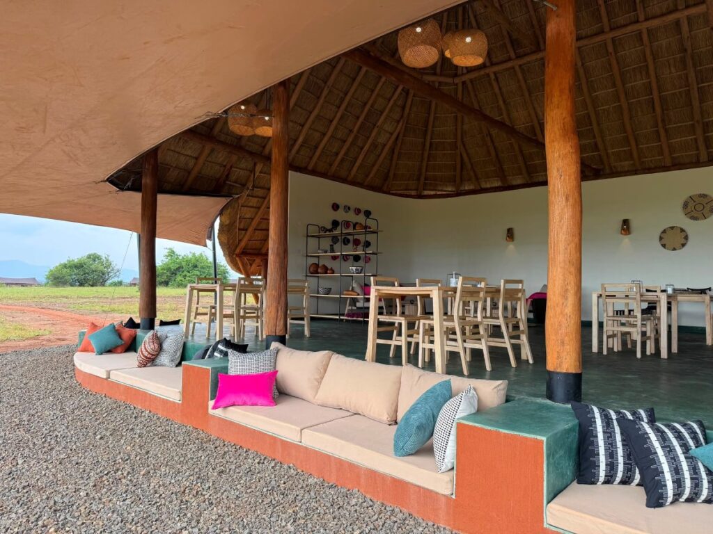 Stylish communal lounge at Namoni Lodge featuring comfortable outdoor seating and traditional thatched architecture, blending seamlessly with the Karamoja landscape