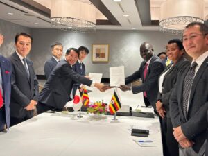 Eng. Isaac Wani, Commissioner for National Roads at Uganda’s Ministry of Works and Transport, and Mr. Osamu Tanabe of Zenitaka Corporation exchange the signed contract for the construction of the New Karuma Bridge, witnessed by officials from both countries