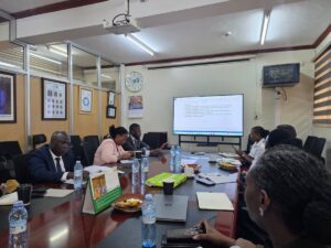 Stakeholders review documents and discuss strategies during a planning session for the Uganda-Kenya Coast Tourism & Innovation Summit, focused on unlocking regional tourism opportunities through technology, youth, and seamless mobility