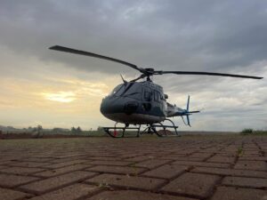 Kampala Executive Aviation’s helicopter (registration ZT-RTB) stands ready on the tarmac near Entebbe as evening light breaks through the clouds, offering travellers scenic aerial views of Lake Victoria and Uganda’s landscapes