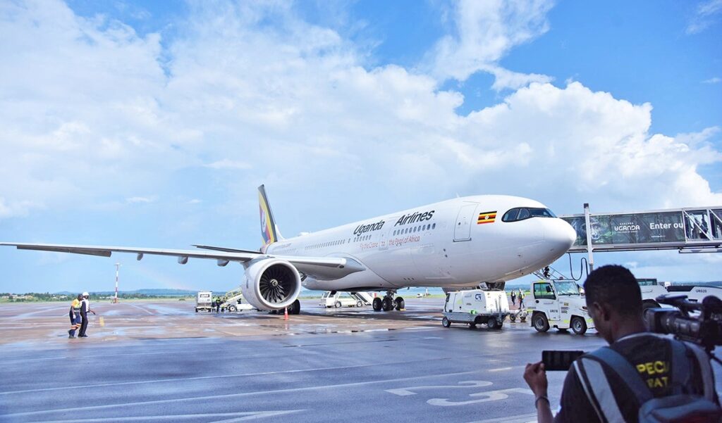 A Uganda Airlines aircraft stands on the tarmac at Entebbe International Airport, showcasing the national carrier’s distinctive “Pearl of Africa” livery