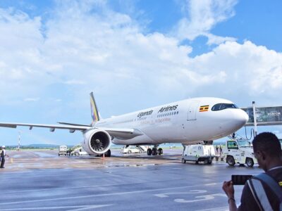 A Uganda Airlines aircraft stands on the tarmac at Entebbe International Airport, showcasing the national carrier’s distinctive “Pearl of Africa” livery