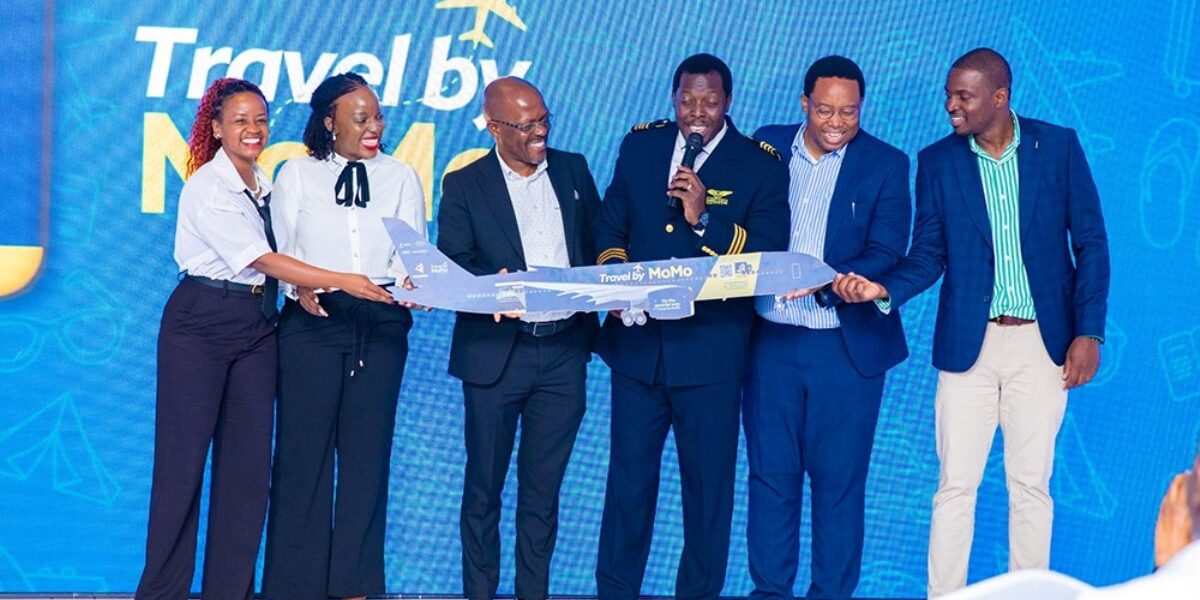 MTN MoMo and Next Travel officials, joined by a pilot, unveil a model aircraft branded “Travel by MoMo” during the official launch of the new digital flight booking platform in Uganda
