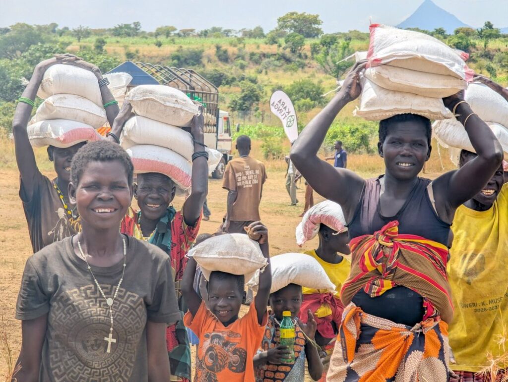 Community members in Karamoja carry vital food relief supplies following the 2026 Karamoja Hunger Run, turning solidarity into tangible support for families facing drought-related shortages