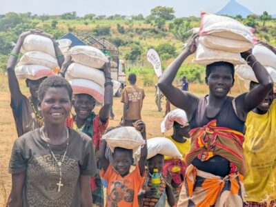 Community members in Karamoja carry vital food relief supplies following the 2026 Karamoja Hunger Run, turning solidarity into tangible support for families facing drought-related shortages