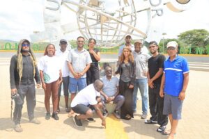 A group of visitors gathers for a photograph at the Kikorongo Equator Monument during a tourism experience in western Uganda