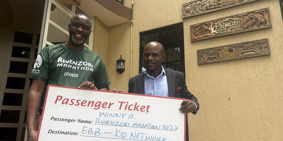 Amos Wekesa and Kenya Airways Country Manager Felix Mwangangi pose with the ceremonial Kenya Airways passenger ticket awarded to the winner of the Rwenzori Marathon 2027